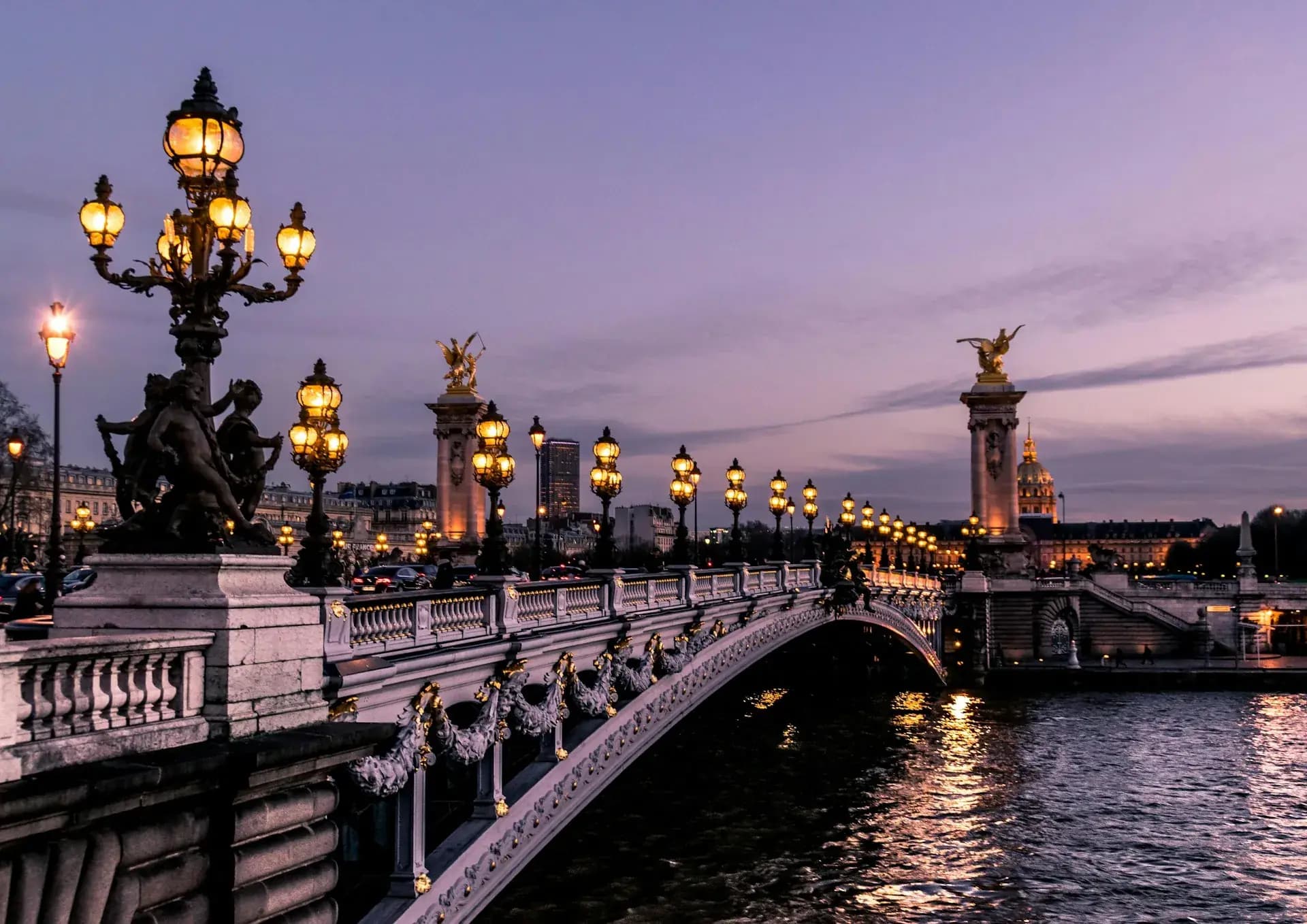 Pont Alexandre III in Paris lit at dusk with golden lamps on a luxury France tour
