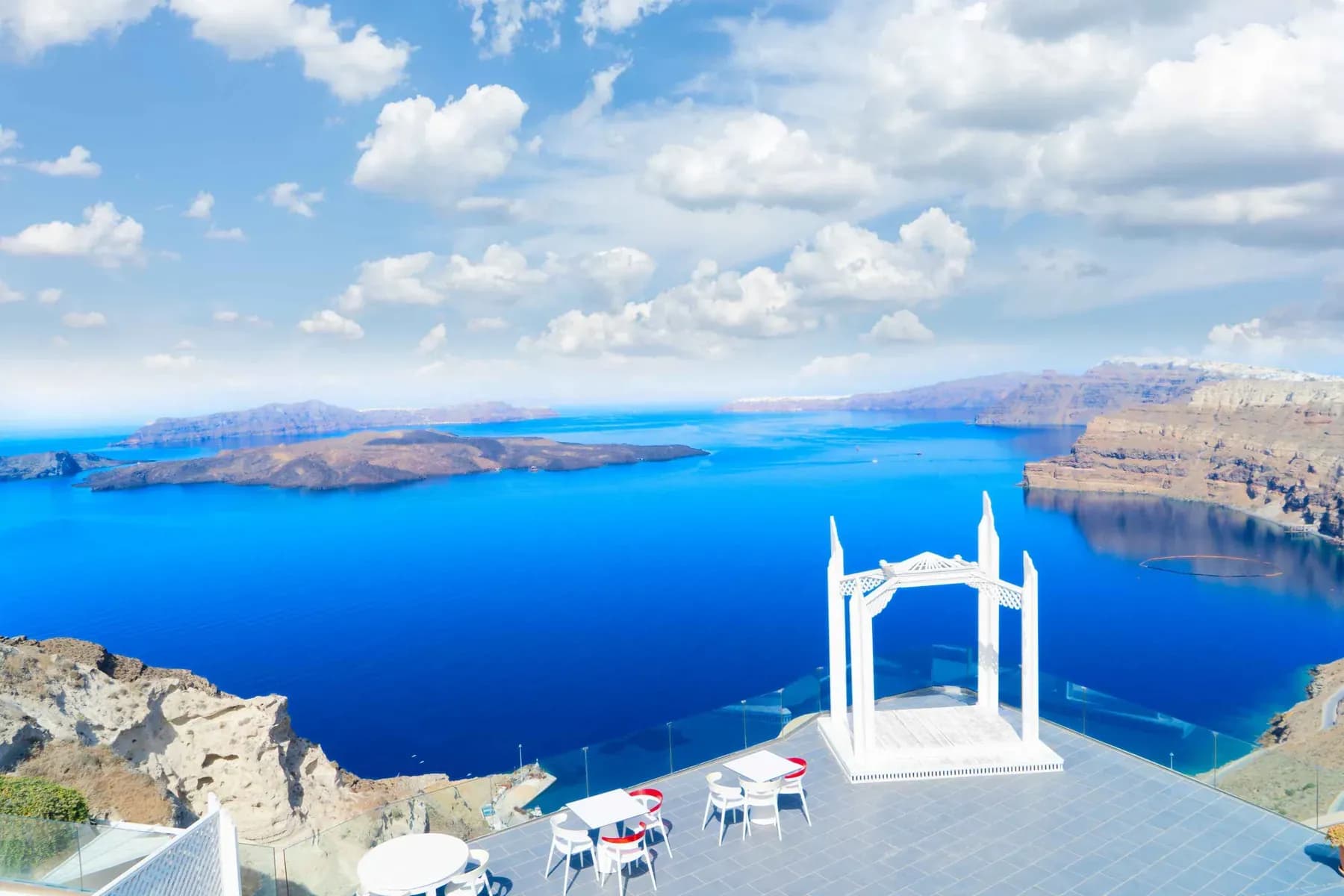 White arch framing the deep blue Santorini caldera on a Greek escape