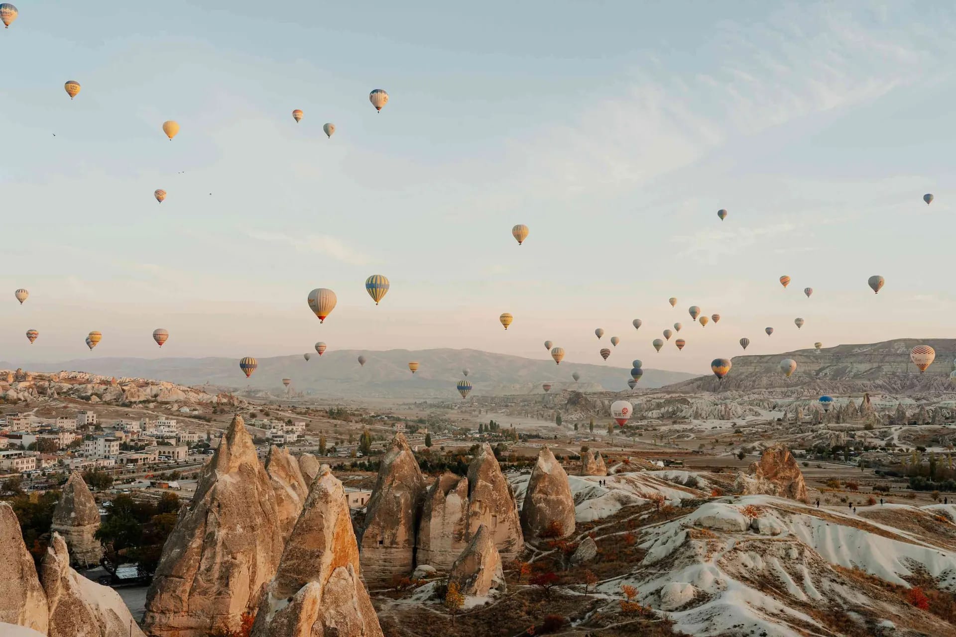 Hot air balloons rising at sunrise over the fairy chimney valleys of Cappadocia, Turkey