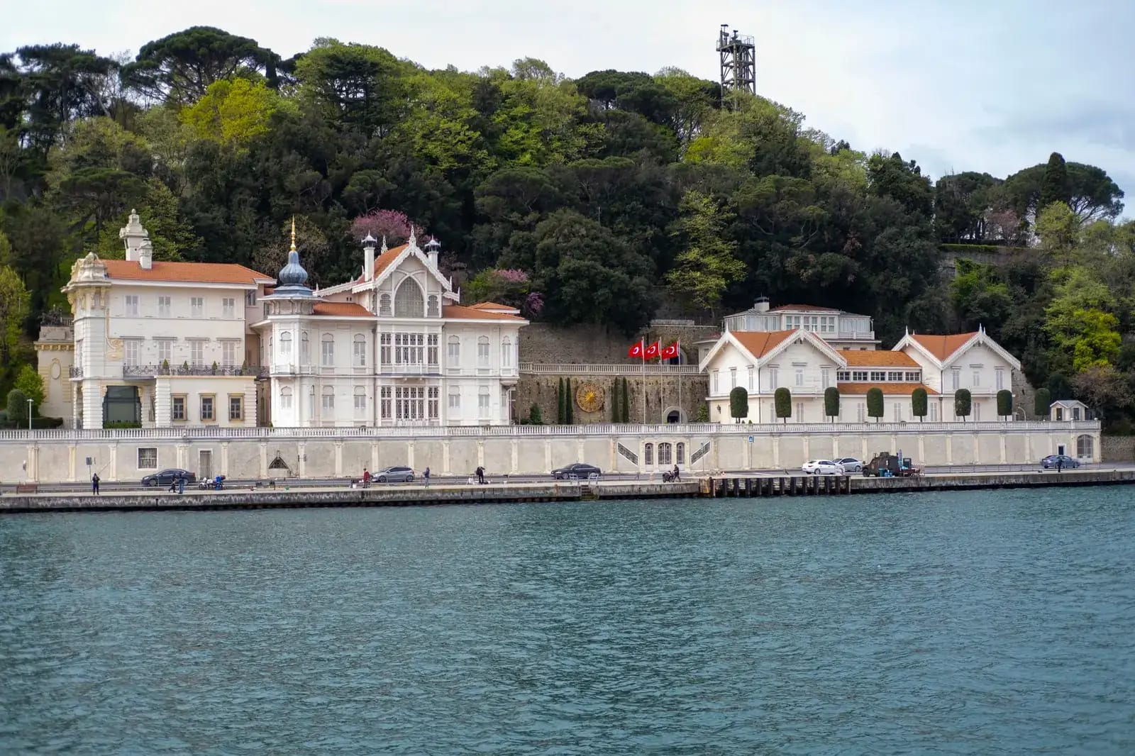 The Bosphorus strait in Istanbul at golden hour with ferries, waterfront mansions and the city skyline behind