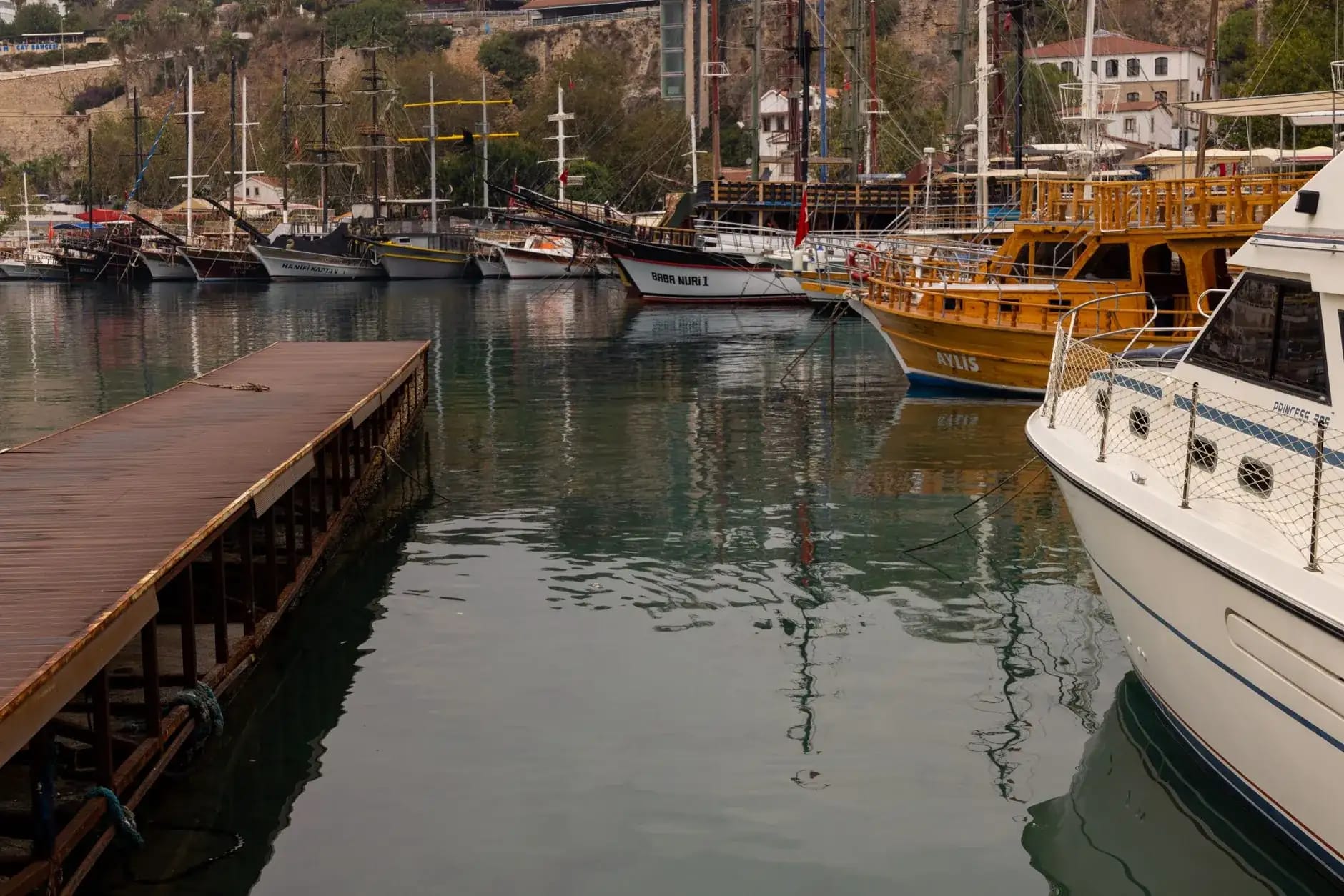 A traditional wooden gulet anchored in a turquoise bay on the Aegean coast near Bodrum, Turkey