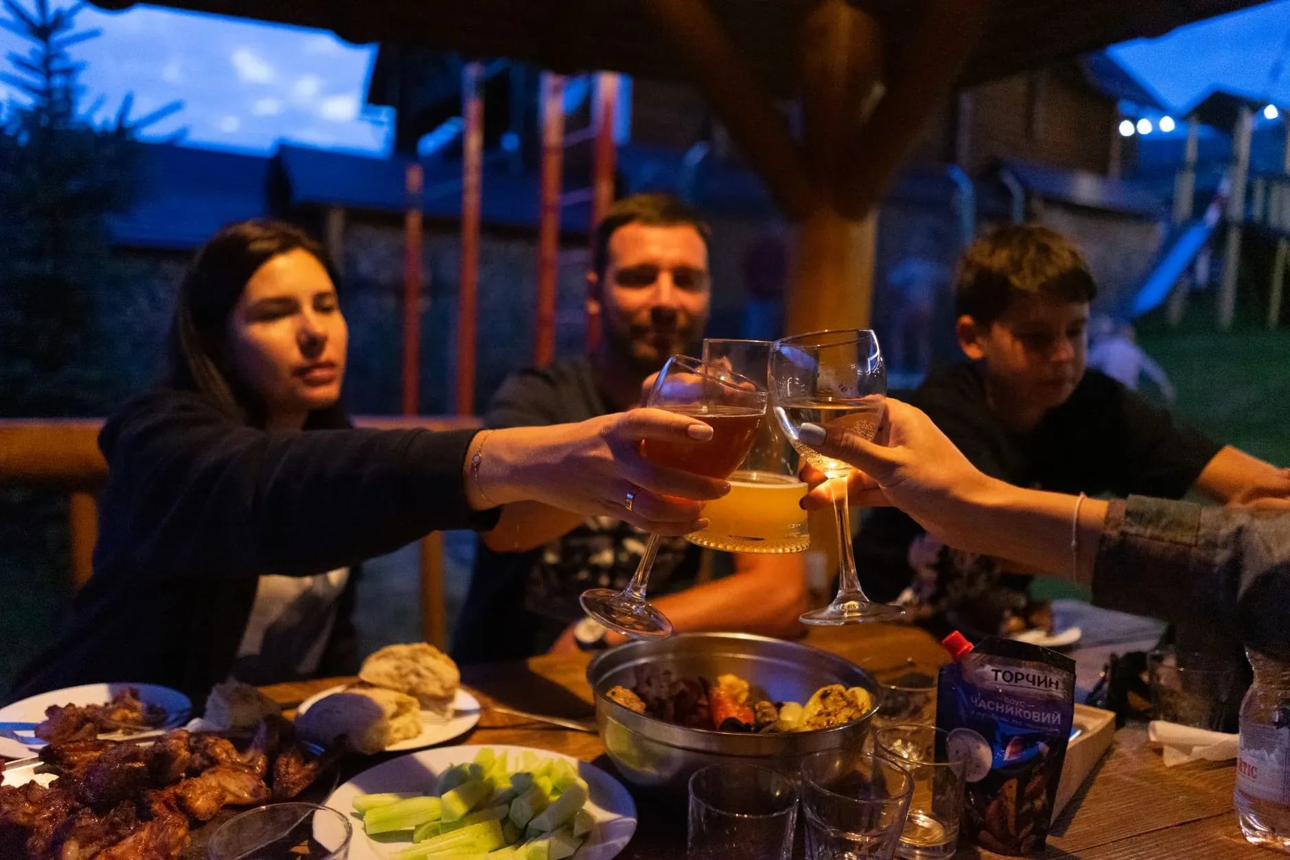 Group of friends toasting at a long dinner table while traveling