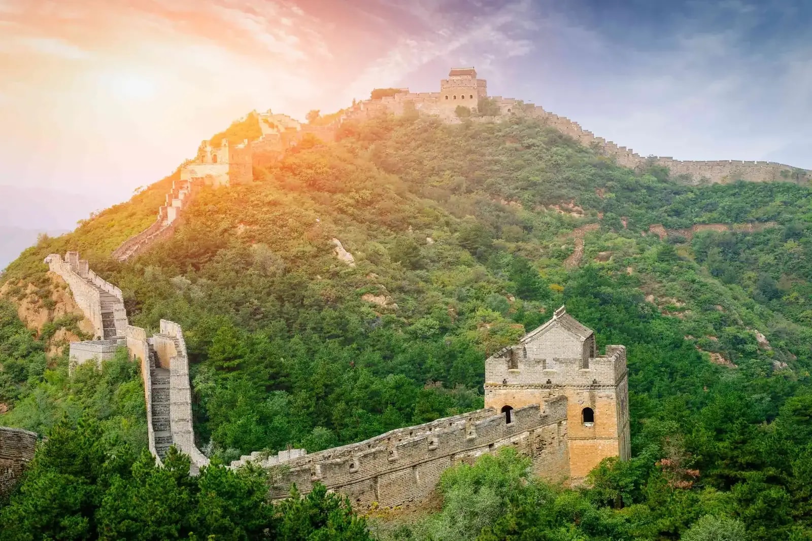 The Great Wall of China snaking along a forested mountain ridge